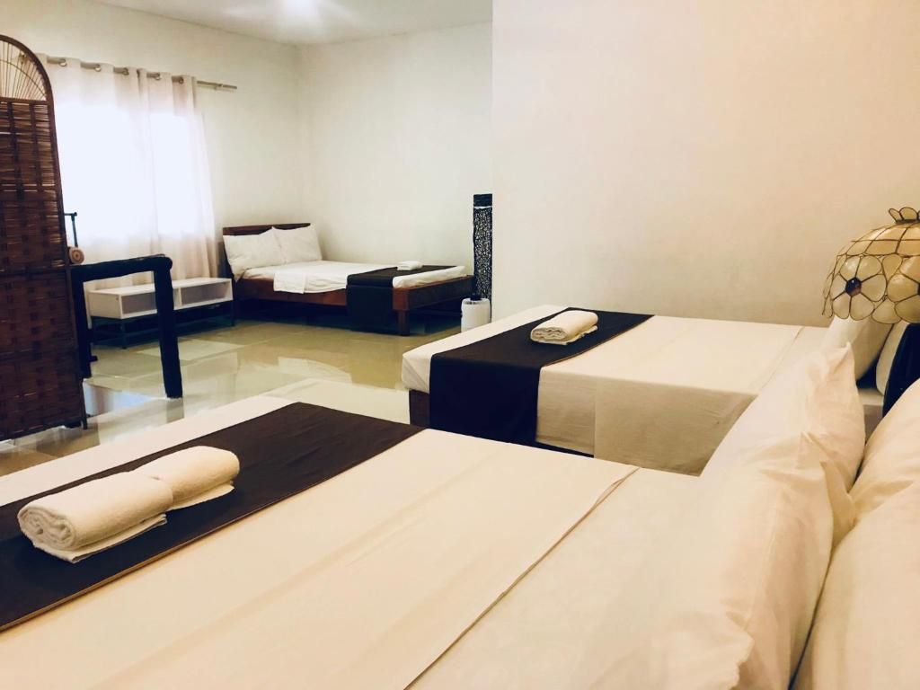 A hotel room with two beds, a sitting area, and a small table.