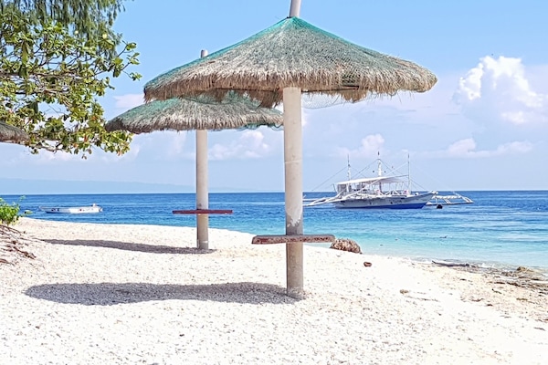 Praia particular, areia branca, guarda-sóis, prática de pesca