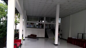 Un espacio interior amplio con una escalera, un banco y una mesa.