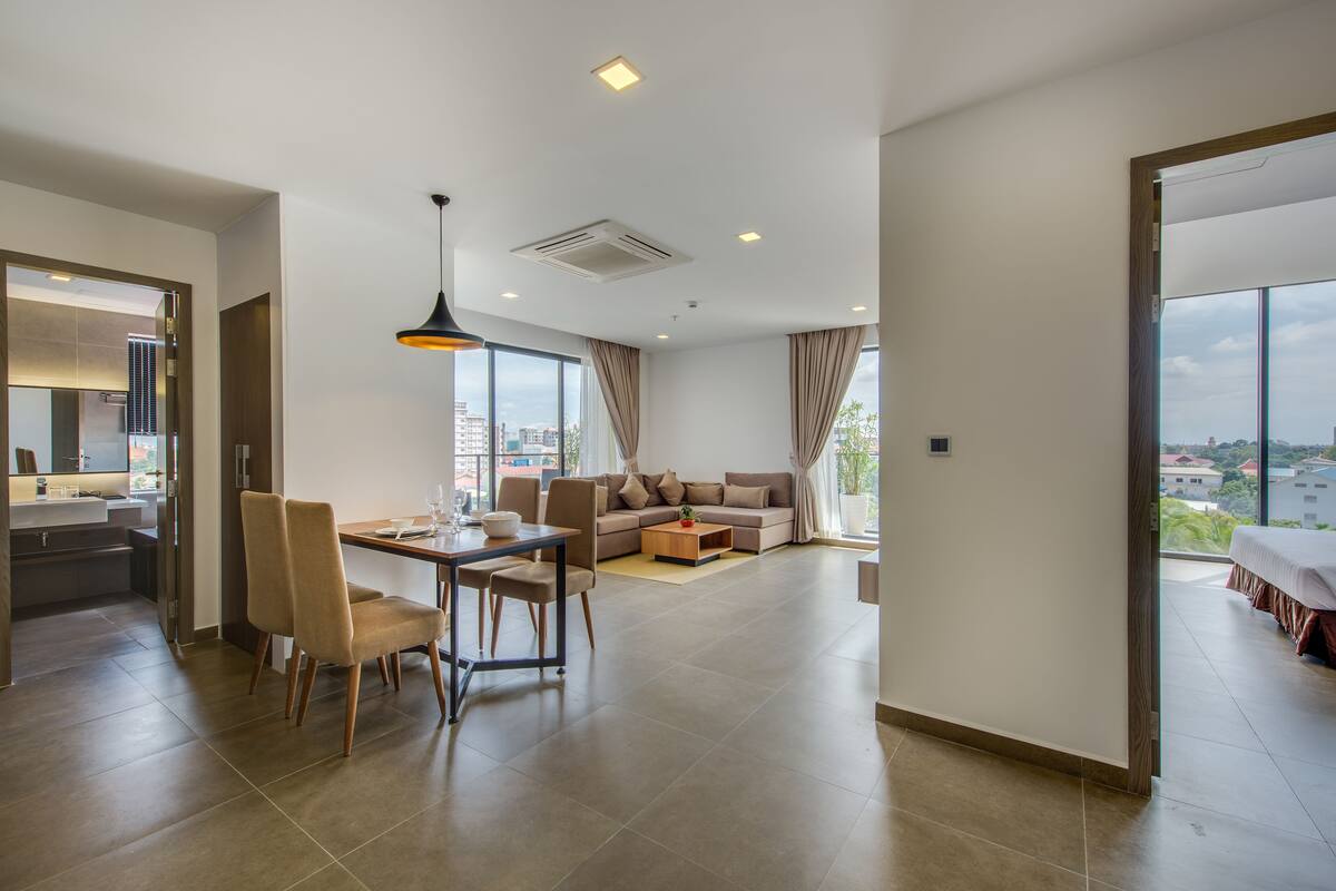 Una sala moderna con comedor, ventanas amplias y vistas a la ciudad.