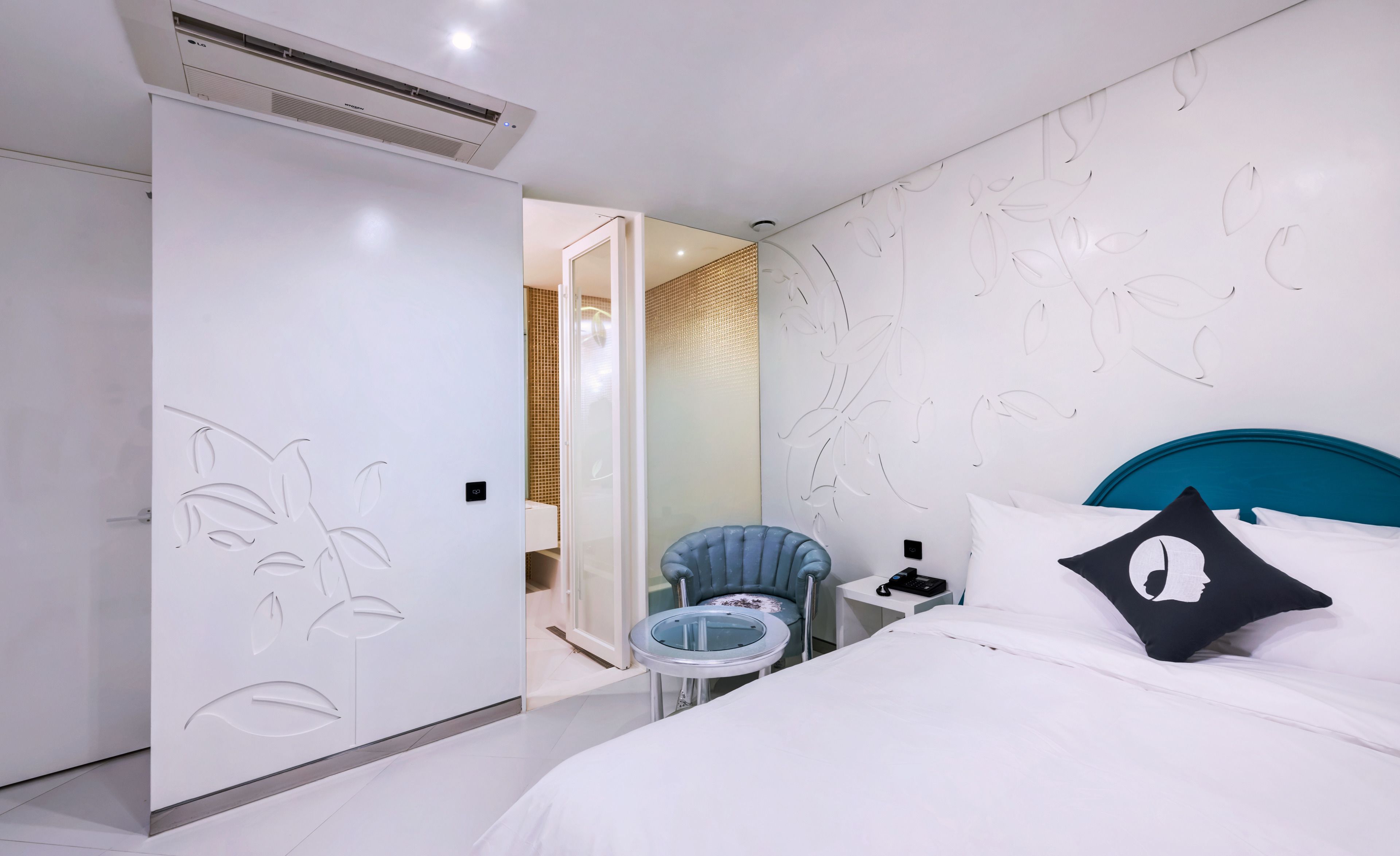 A modern bedroom with a bed, a chair, and a small table.