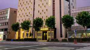 Un hotel moderno con un letrero llamativo que dice 'GRAND OPEN HOTEL THE DESIGNERS'.