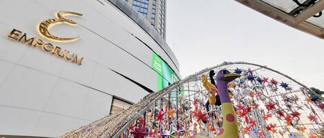 A building with a prominent sign reading "EMPORIUM" and a large, colorful sculpture of a bird.