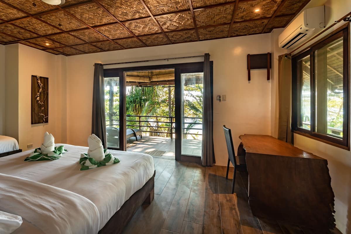 Une chambre d’hôtel avec un grand lit, un bureau en bois et une vue sur l’extérieur.
