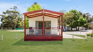 A small, single-story structure with a red roof and white railings, surrounded by a grassy area and trees. - Discovery Parks - Grampians (Halls Gap)