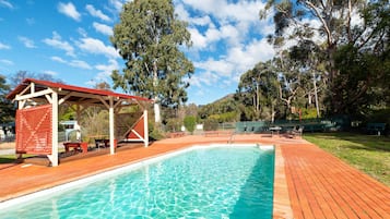 Una piscina al aire libre de temporada, sillones reclinables de piscina