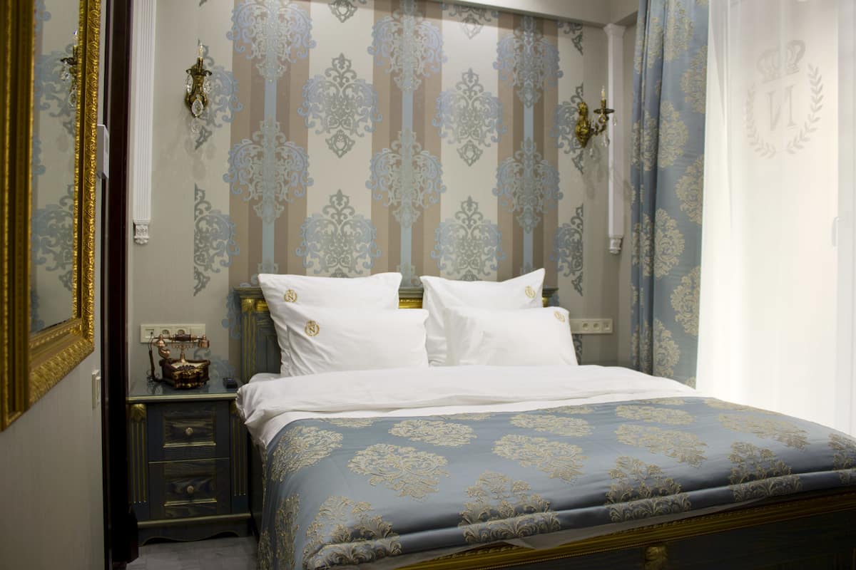 A bedroom with a bed, nightstands, and a dresser.