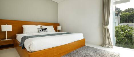 A modern bedroom with a wooden bed, white bedding, and a grey rug.