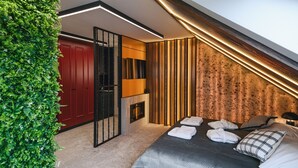 Un dormitorio moderno con cama, toallas y una pared verde.