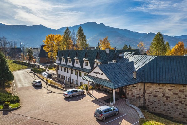 Un hotel de estilo arquitectónico europeo tradicional, con una entrada destacada, un porche cubierto y un letrero.