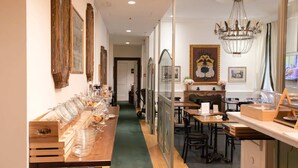 A long dining table with glassware and plates, flanked by wooden crates and a green carpet. - Relais Donna Lucrezia (Rome)
