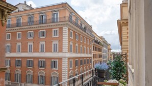 A multi-story building with balconies, a staircase, and a potted plant. - Relais Donna Lucrezia (Rome)