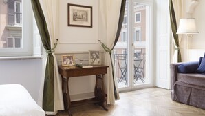 A room with a wooden desk, a framed picture, and a window with curtains. - Relais Donna Lucrezia (Rome)