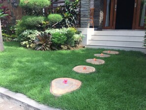 Un jardín cuidado con un camino de piedra que lleva a la entrada de un edificio.