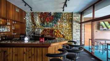 Een bar met houten kasten, een bar en een kleurrijke mozaïekwand.