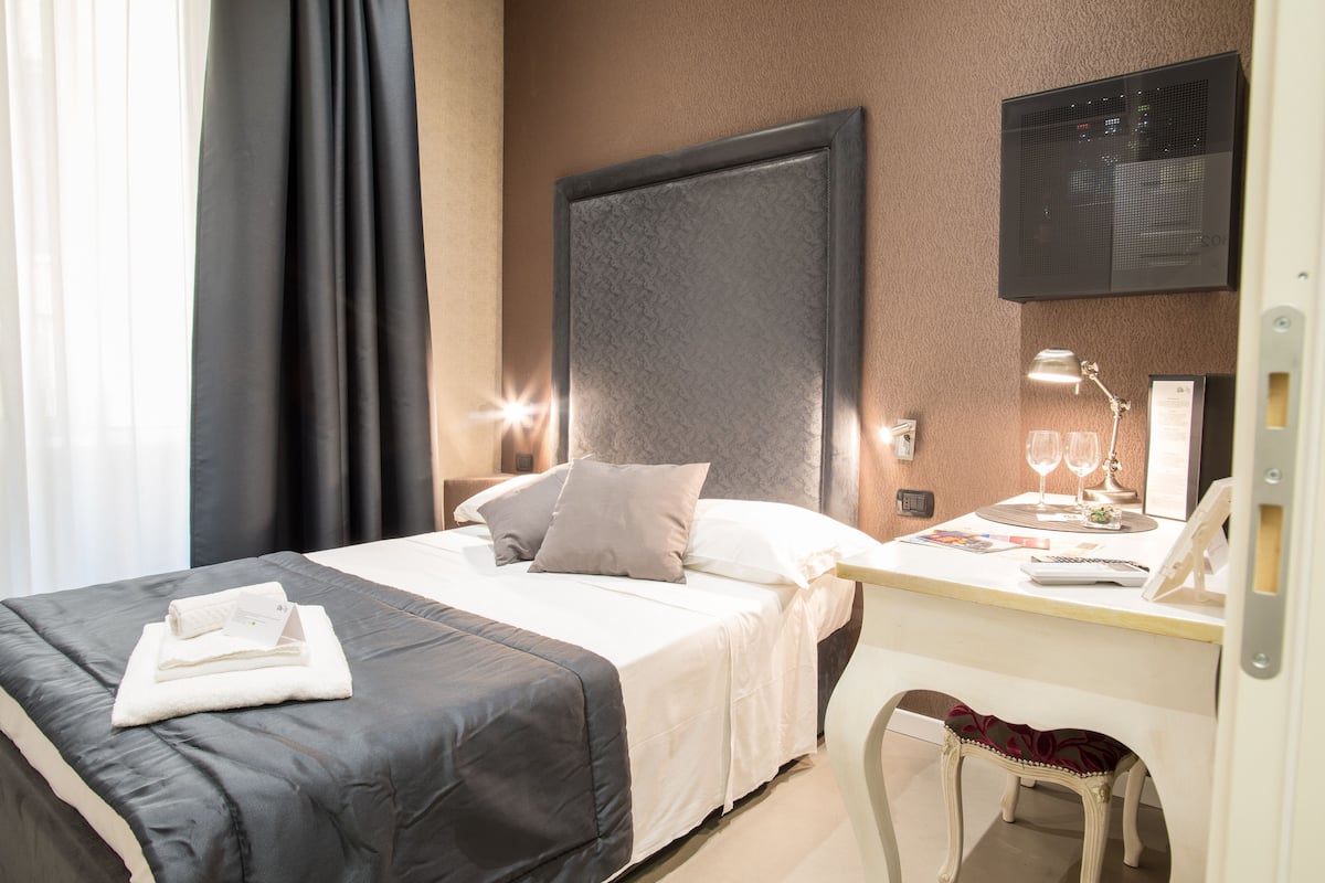 Habitación económica | Edredón, minibar, caja de seguridad en la habitación y escritorio