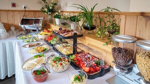 Una mesa de buffet con diversos alimentos y una estación de café.