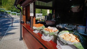 Un puesto de comida con diversos productos horneados exhibidos sobre un mostrador de madera.