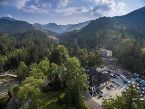 Un paysage montagneux avec un bâtiment entouré d’une forêt dense.