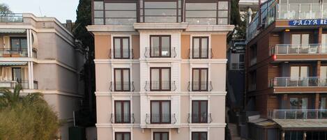 Un hotel con un patio central, mobiliario exterior y diversas plantas.