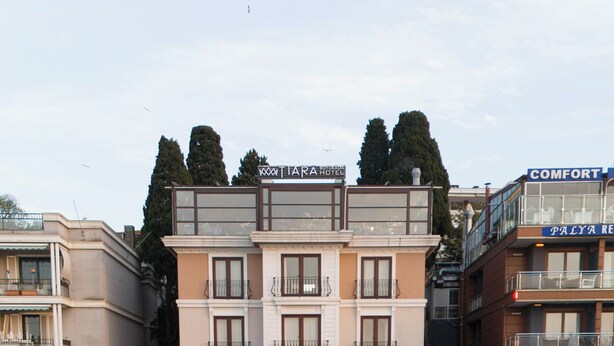 Un hotel con un patio central, mobiliario exterior y diversas plantas.