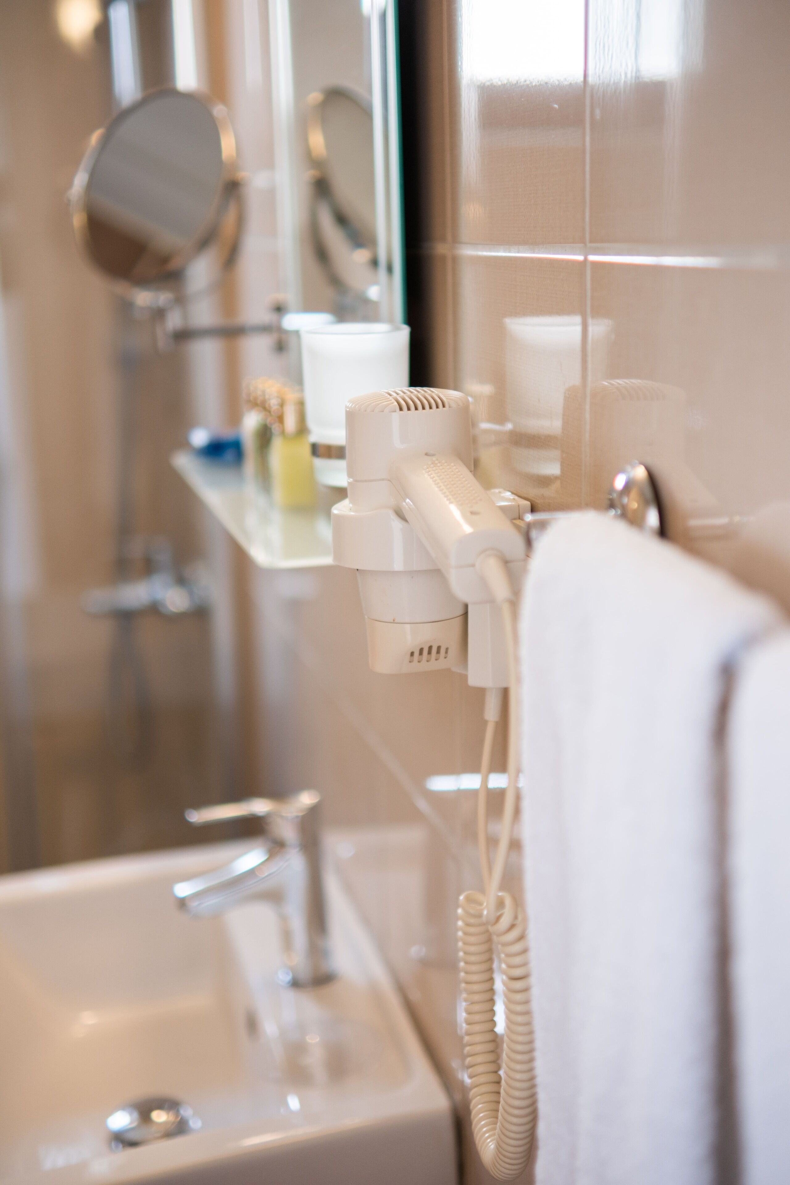 A bathroom with a sink, mirror, and hairdryer on a counter.