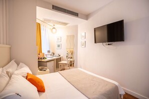 A hotel room with a bed, a desk, a chair, a television, and a mirror. - Tiara Buyukada (Adalar)