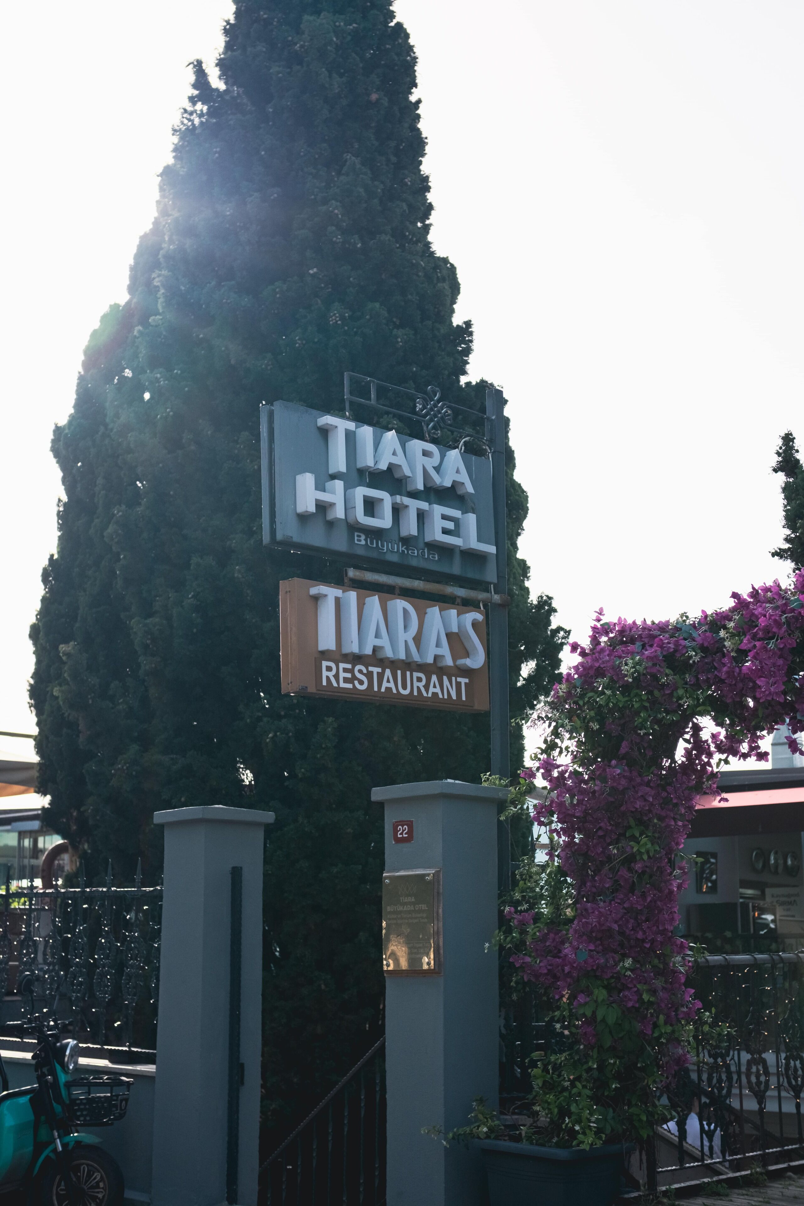 Placa de hotel com a inscrição 'TIARA HOTEL' e 'RESTAURANTE TIARA'.
