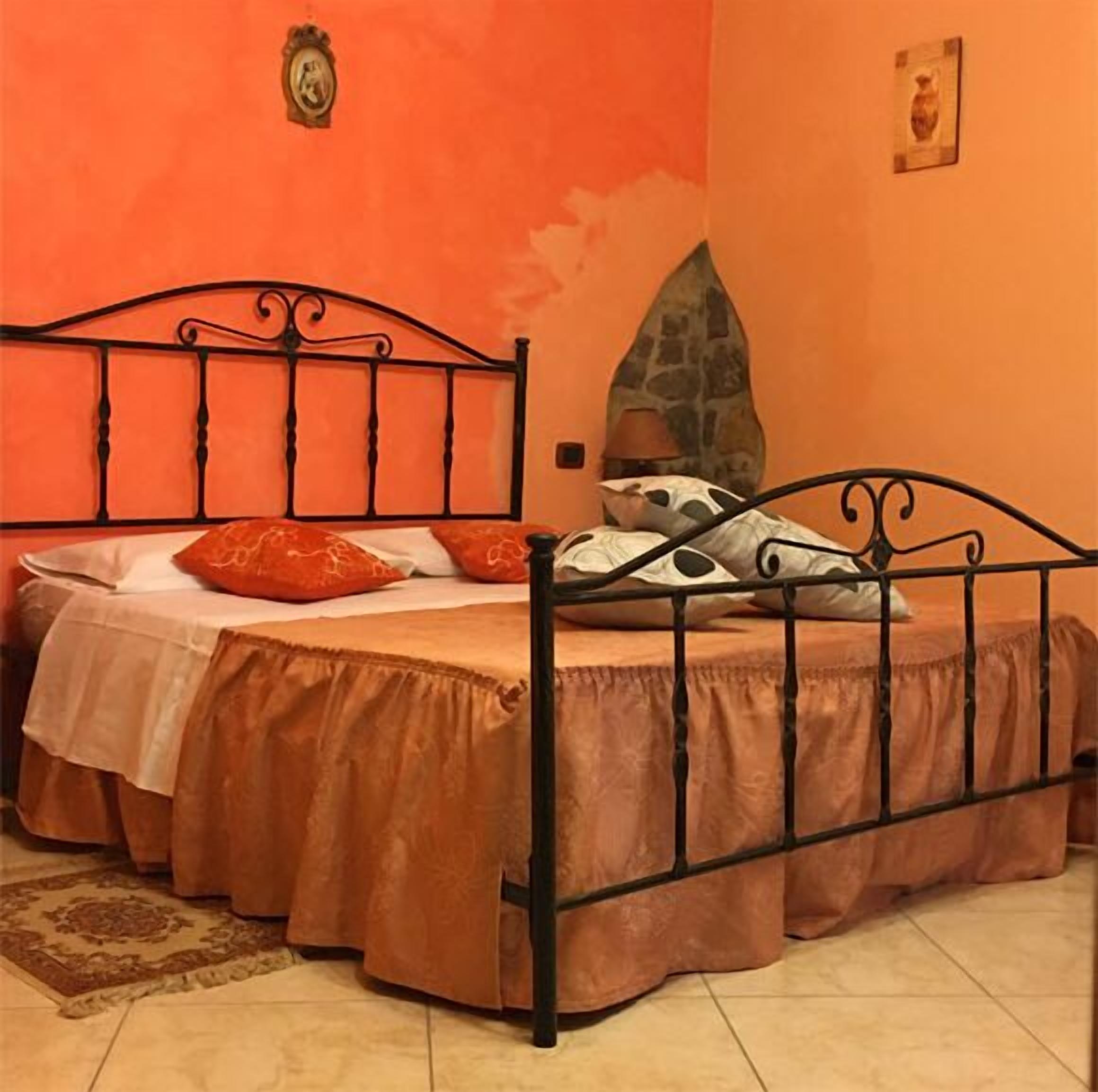 A bedroom with a bed, pillows, and a rug.