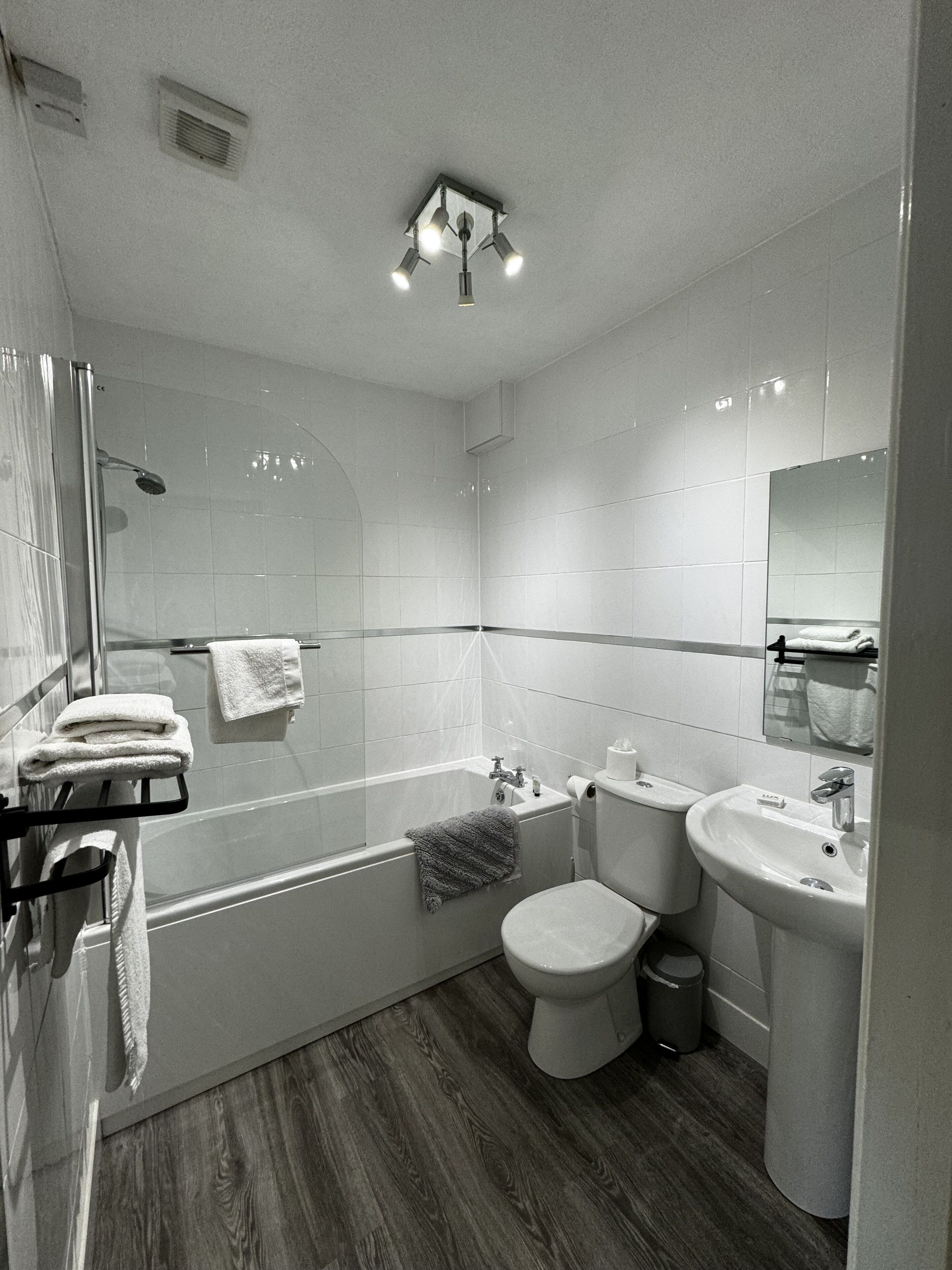 A modern bathroom with a bathtub, toilet, and sink.