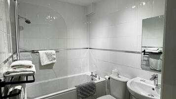 A modern bathroom with a bathtub, toilet, and sink.