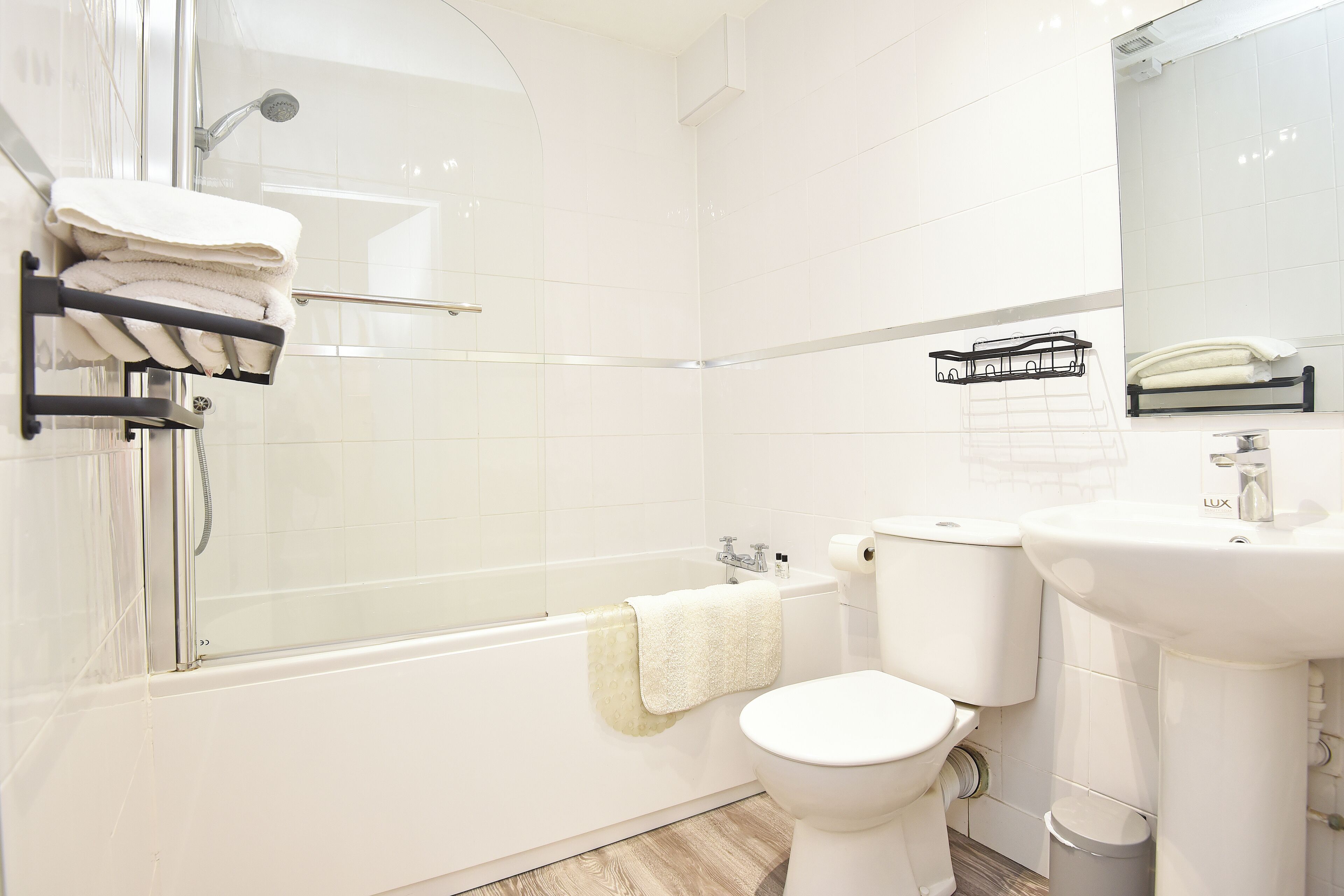 Une salle de bain moderne avec une douche à parois de verre, une baignoire blanche, des toilettes et un lavabo.