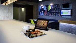 A modern conference room with a white table, a tablet, a magazine, and a cup. - ibis budget Chambéry Sud Challes les Eaux (Challes-les-Eaux)