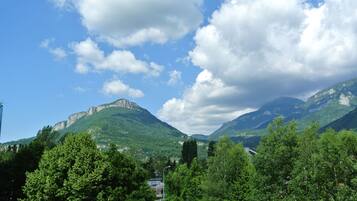 Un paysage montagneux, avec une végétation luxuriante et un ciel bleu azur.