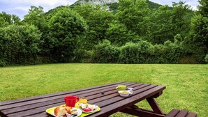Una mesa de picnic con comida y vista a la montaña.