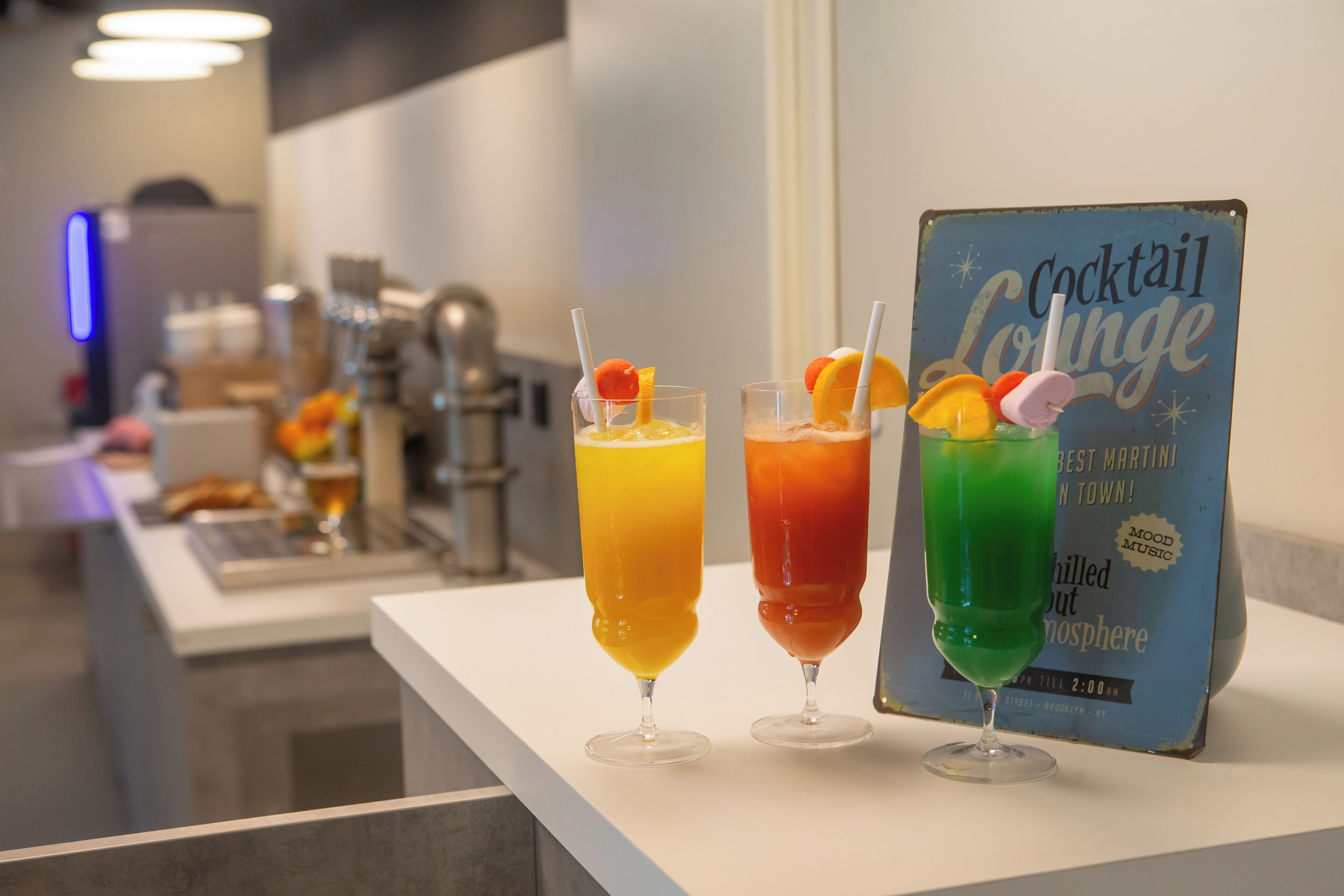 Angolo bar con tre cocktail e un cartello per il lounge bar.