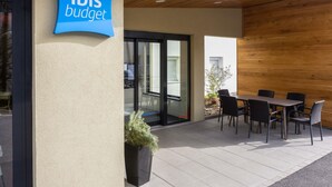 Un área de estar al aire libre con un cartel que indica 'ibis budget' hotel.