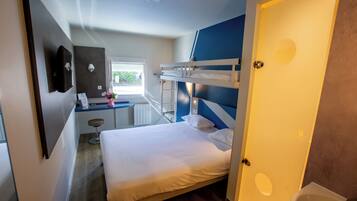A bedroom with a bunk bed, a desk with a chair, a small stool, and a window.
