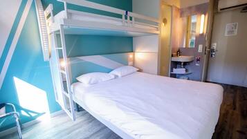 A bunk bed with white bedding, a bedside table, and a mirror.