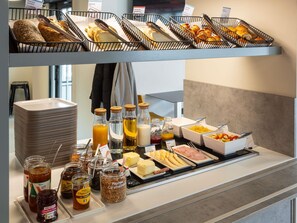 Ein reichhaltiges Frühstücksbuffet mit Brot, Gebäck und verschiedenen Aufstrichen.