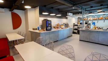 A modern cafe with a central counter, seating area, and a visible coffee machine.