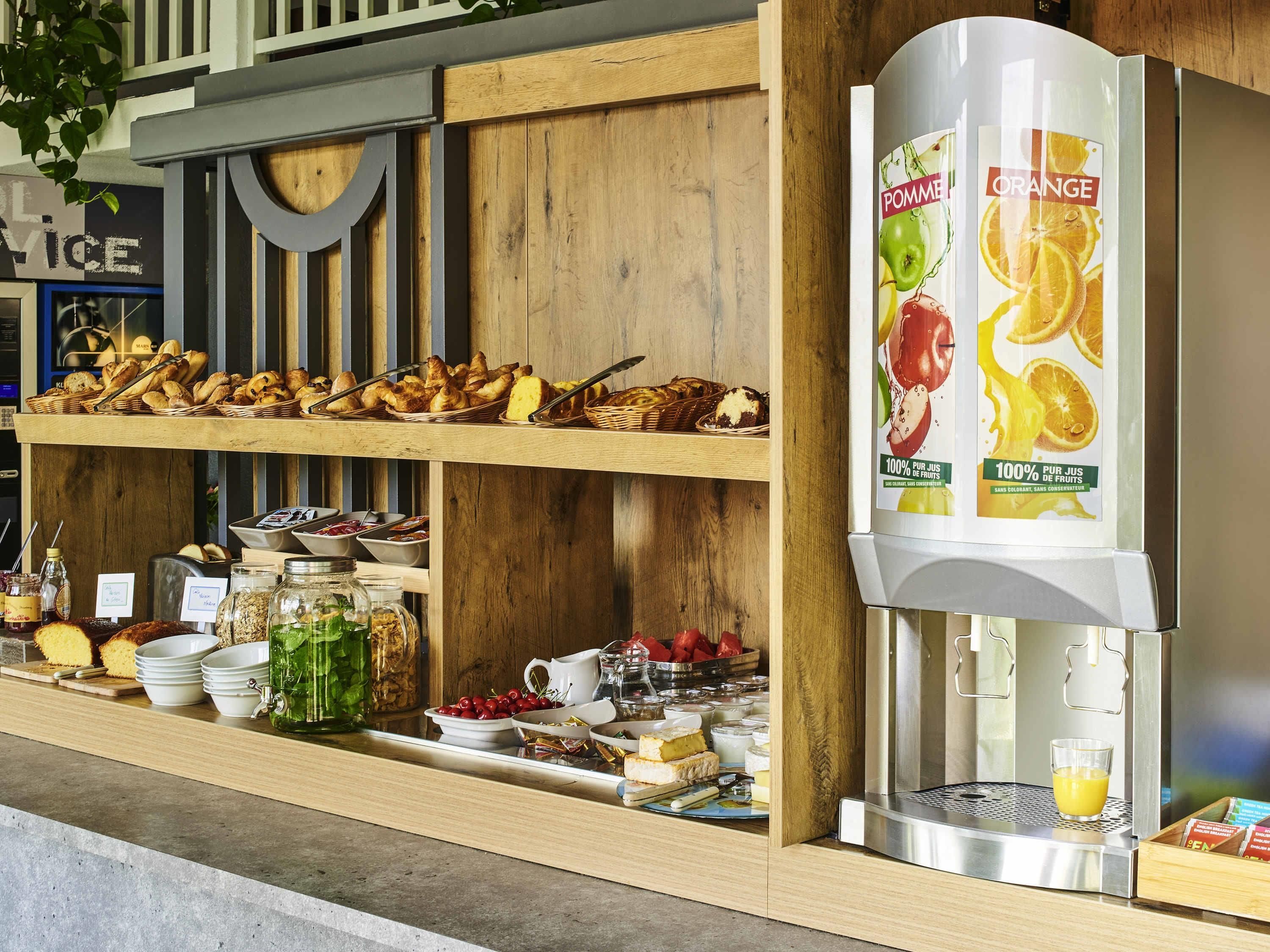 Un buffet de petit-déjeuner proposant une variété de viennoiseries, de fruits et de boissons.