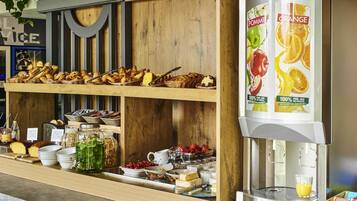 Un buffet de petit-déjeuner proposant une variété de viennoiseries, de fruits et de boissons.