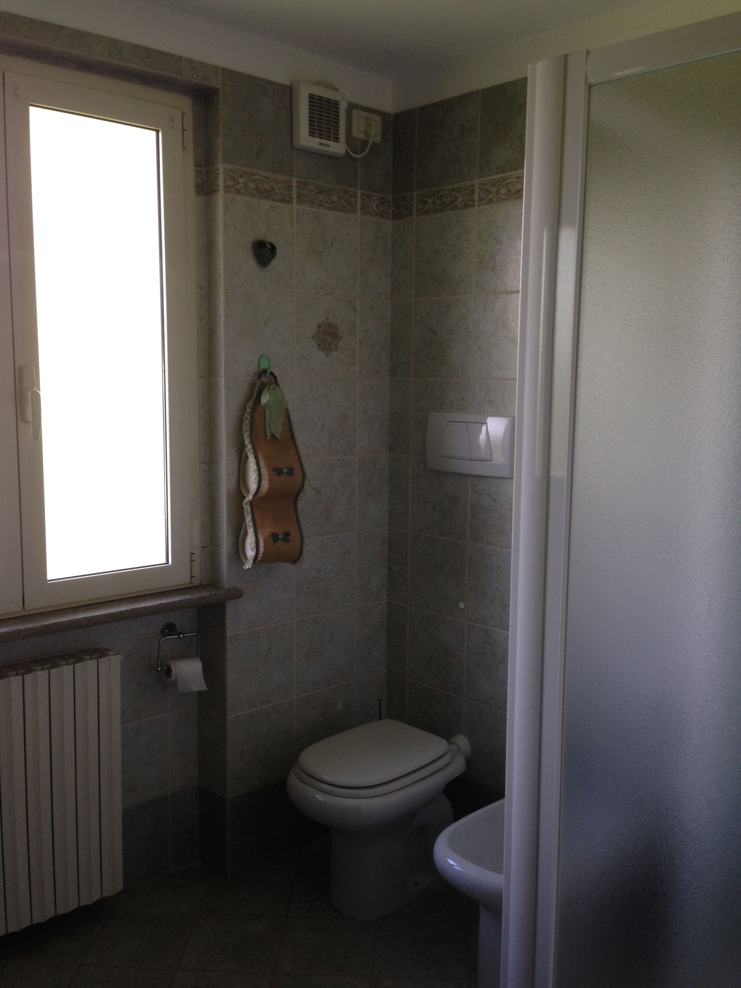 Un baño pequeño con inodoro, toallero y ventana.