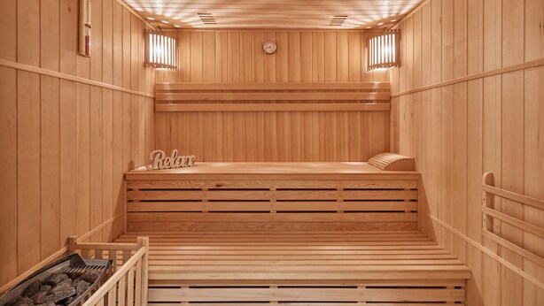 A wooden sauna with benches and a sloped ceiling. - Apart Hotel Akropolis (Karlovy Vary)