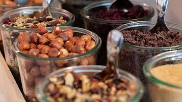 Multiple glass jars containing various nuts and dried fruits.