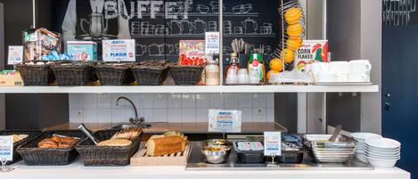 A buffet counter with various food items and utensils.