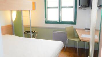 A room with a bunk bed, a desk, a chair, a television, and a window.