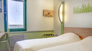 Habitación de hotel con dos camas, una ventana con persianas, un calentador en la pared, un perchero y una obra de arte en la pared.