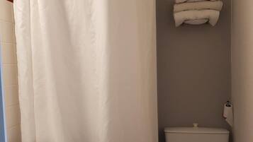 A bathroom with a white sink, toilet, and shower curtain.